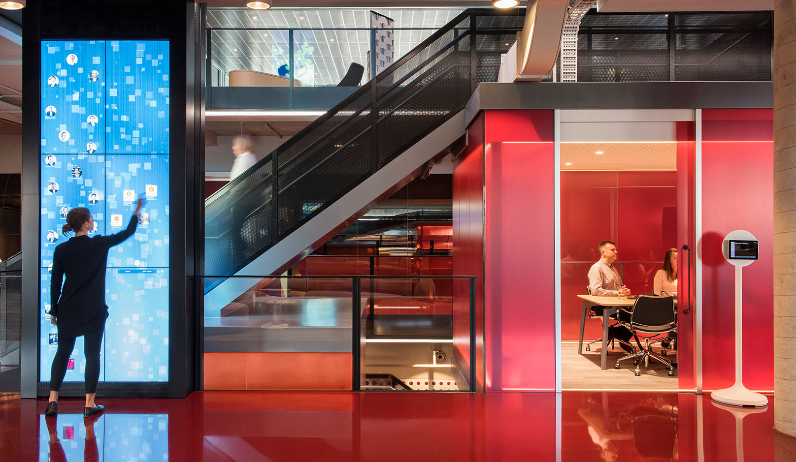 Branded environments with woman using large interactive touch screen. 